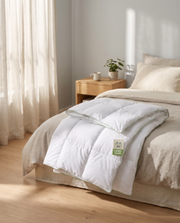 Welldora Komfort Ganzjahresdecke mit Daunen und Federn auf einem gemachten Bett im hellen, ruhigen Schlafzimmer